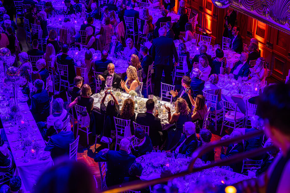 Event participants sit at the tables during a gala event