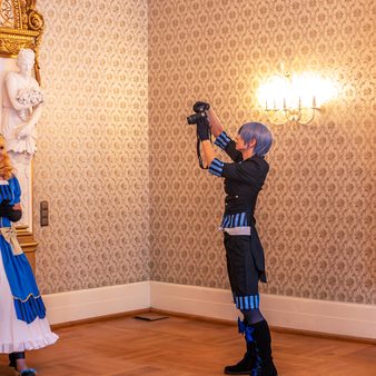 Ein Mann macht ein Foto von einer Frau in einem Cosplay-Kostüm im Kurhaus