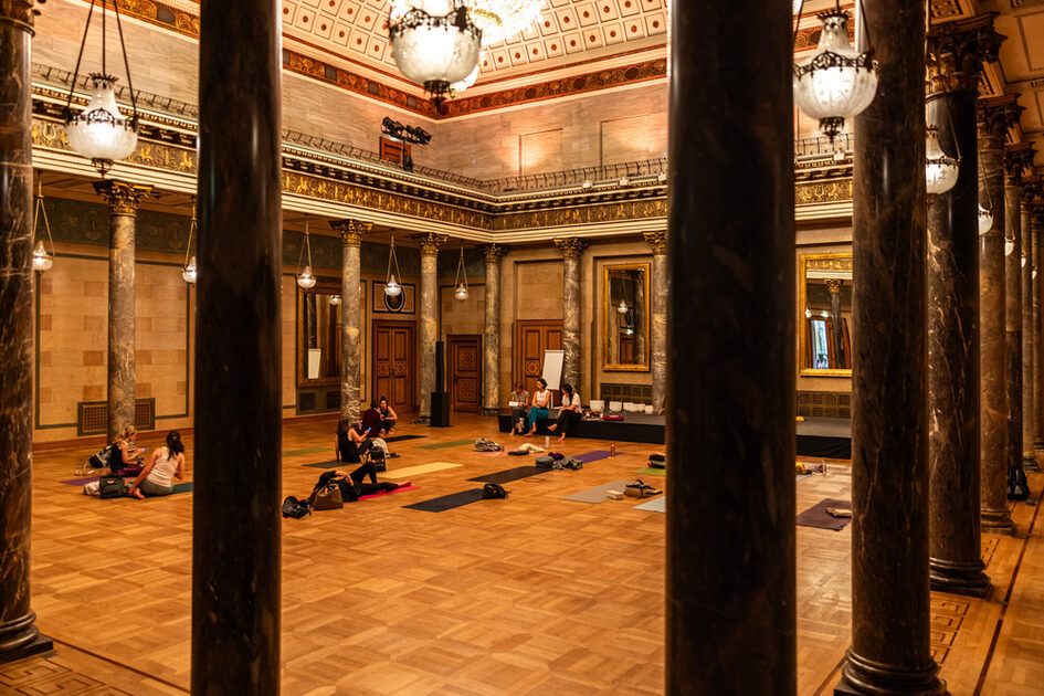 People sit on the yoga mats and listen to the lecture