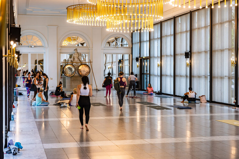 Event guests sit on the yoga mats