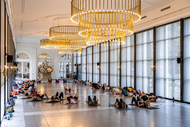 Veranstaltungsgäste machen Yoga auf den Yogamatten im Kreis