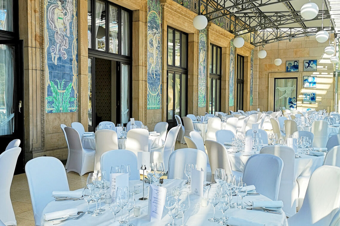 Gala seating (white-covered tables and chairs) in the Kurhaus