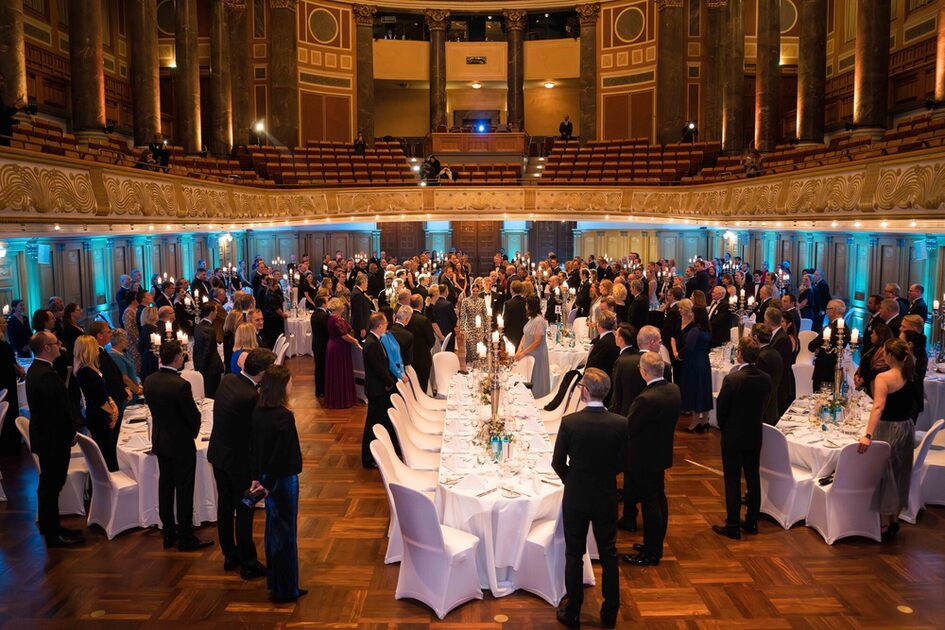 Guests at the evening event stand and welcome the Princess