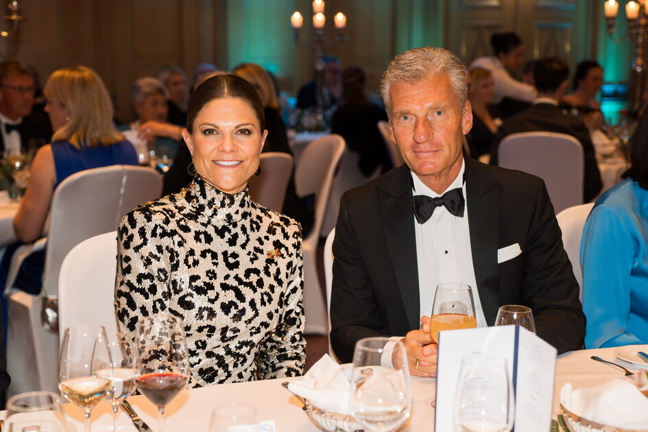 A woman and a man sit at the table, look into the camera and smile