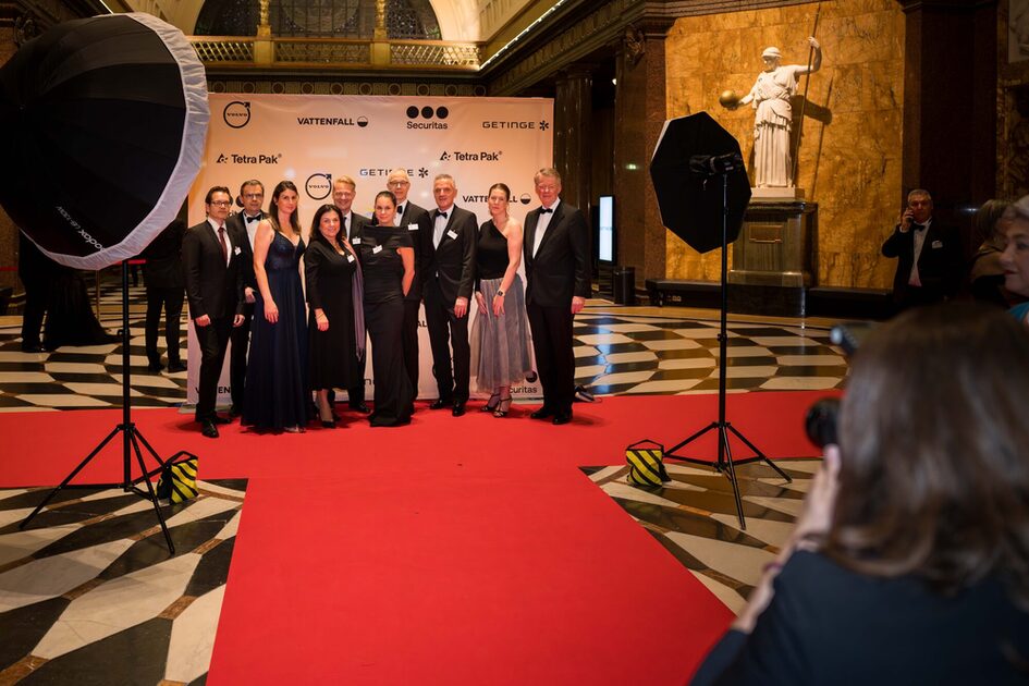 People stand on the red carpet and are photographed.