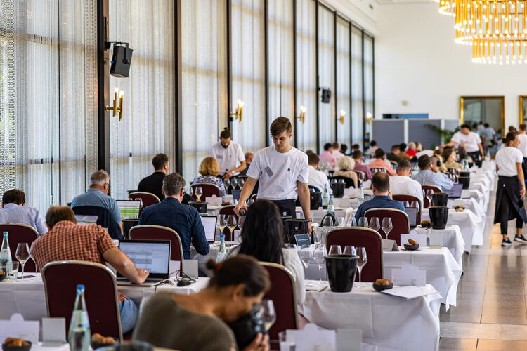 Besucher an Tischen bei der VORPREMIERE VDP.GROSSES GEWÄCHS® 2024 in den Kurhaus Kolonnaden