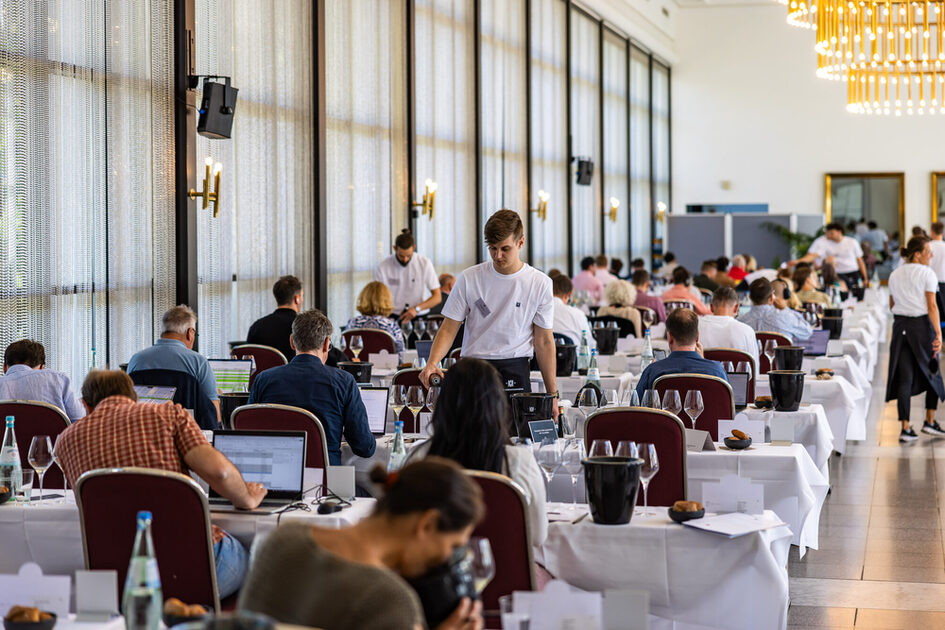 Visitors at tables at the PRE-PREMIERE VDP.GROSSES GEWÄCHS® 2024 in the Kurhaus Kolonnaden