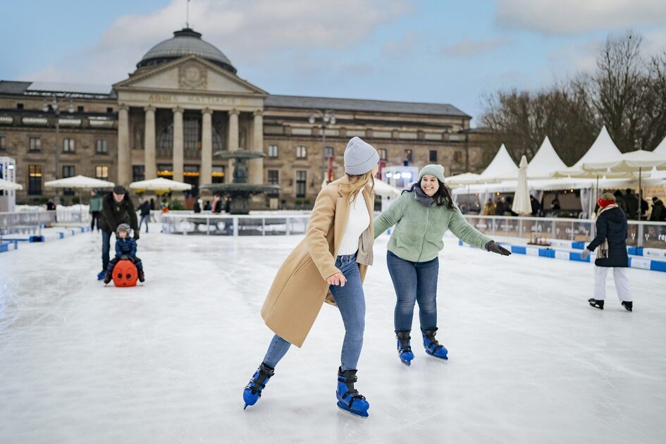 Two women on the Wiesbaden on Ice in front of the Kurhaus