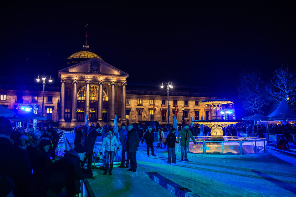 People on the ice rink in front of the Kurhaus