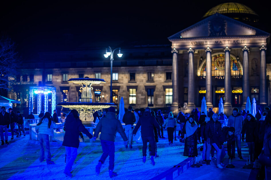 People on the ice rink in front of the Kurhaus