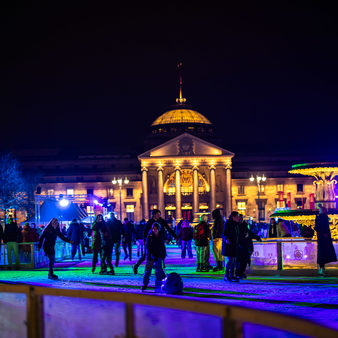 Menschen auf der Eisbahn vor dem Kurhaus