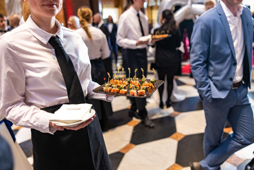 Eine Kellnerin hält ein Tablett mit dem Essen