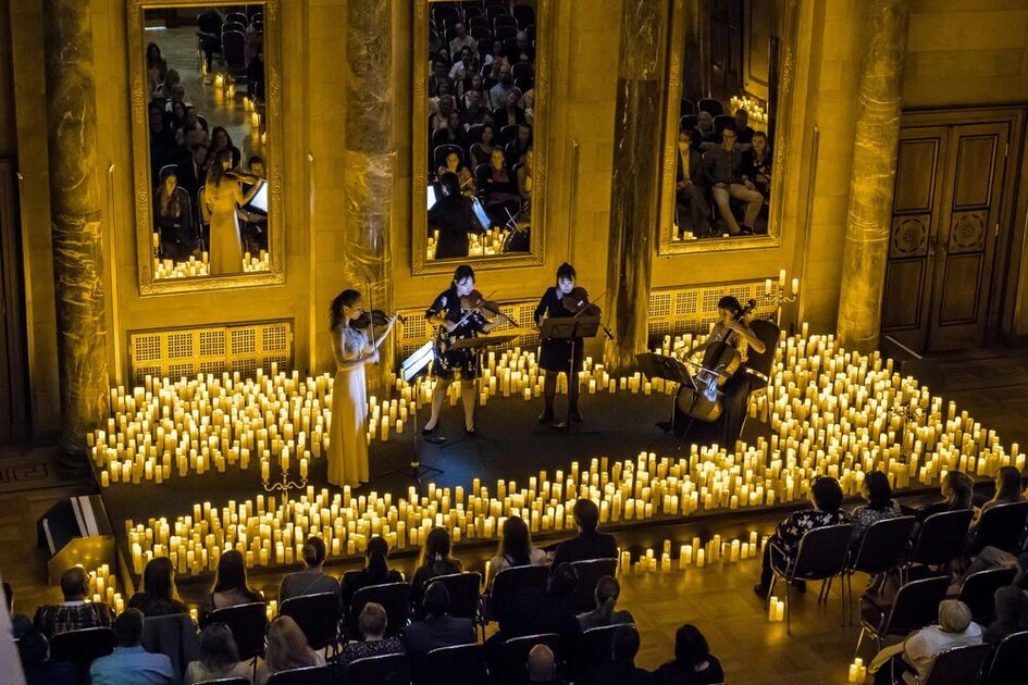 Musiker spielen Musik umgeben von Kerzen