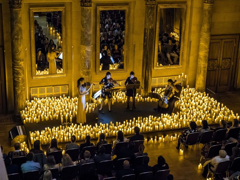 Musiker spielen Musik umgeben von Kerzen